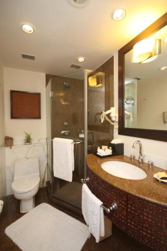 a bathroom with a sink and a shower and a toilet at Taj Bengal in Kolkata