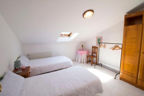 a hotel room with two beds and a table at Casa Rural El FerJo in Colunga