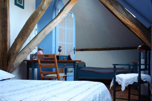 Schlafzimmer mit einem Bett, einem Schreibtisch und einem Stuhl in der Unterkunft Une Parenthèse en Champagne in Jaucourt