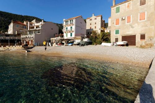 a group of buildings on a beach next to the water at Beach House Gusla in Komiža