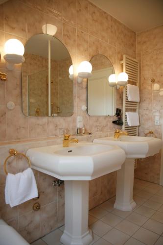 a bathroom with two sinks and a mirror at Hotel-Restaurant Zum Landgraf - Henry Merz in Wartmannsroth