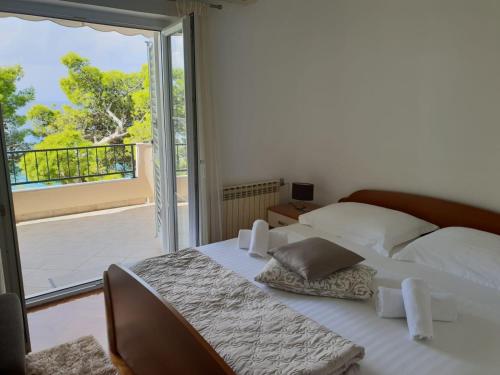 sypialnia z łóżkiem i balkonem z widokiem na okolicę w obiekcie Guesthouse Marina w Tučepi