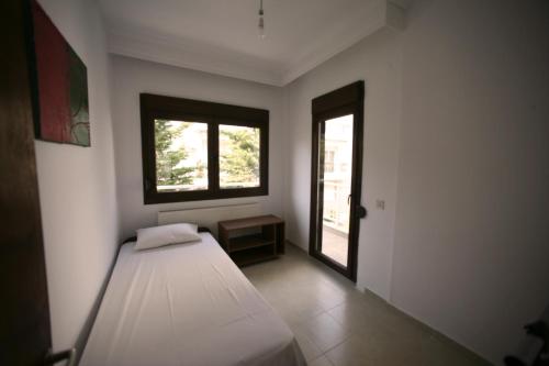 a small room with a bed and a window at Luminous Apartment in Agia Triada