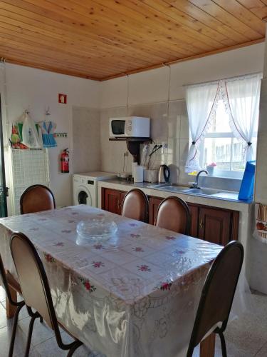 a kitchen with a table and chairs and a kitchen with a table and a table at Casa dos biscoitos in Madalena