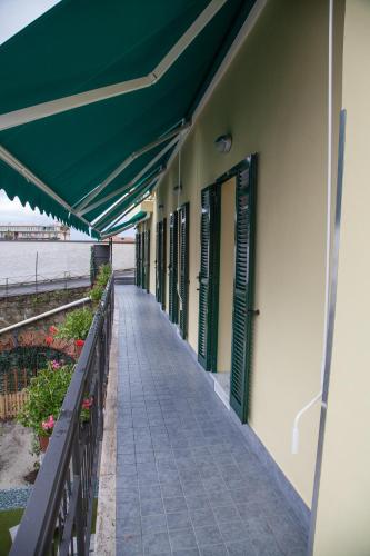 a building with a green awning and a walkway at Casa delle Ginestre Bike in Sanremo
