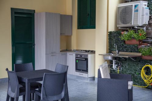 a kitchen with a table and chairs and a stove at Casa delle Ginestre Bike in Sanremo