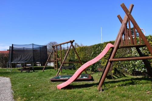 a playground with a pink slide in the grass at Ferienhof Christian und Antje Hopp in Fehmarn
