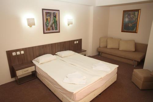 a small bedroom with a bed and a couch at Hotel Laguna in Lozenets
