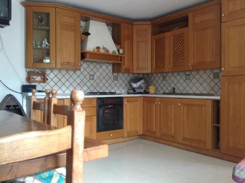 a kitchen with wooden cabinets and a stove top oven at Castel Di Gufi in Comano