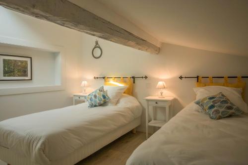 twee bedden in een kamer met twee lampen op tafels bij Gîte Le Cocoon d'Isatis 2 in Montgiscard