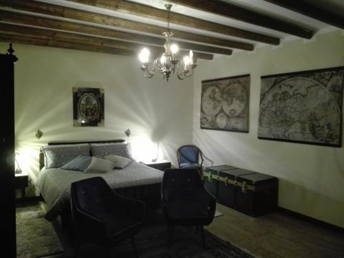 a bedroom with a bed and a chandelier at La Casa del Comandante in Sulzano