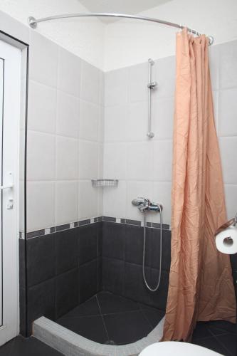 a shower with a shower curtain in a bathroom at Hotel Laguna in Lozenets
