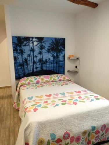 um quarto com uma cama com colcha floral em Casa Bera em Arnedillo
