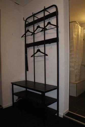 ein schwarzes Regal mit Kleiderbügeln in einem Zimmer in der Unterkunft Matten Central Studio in Matten