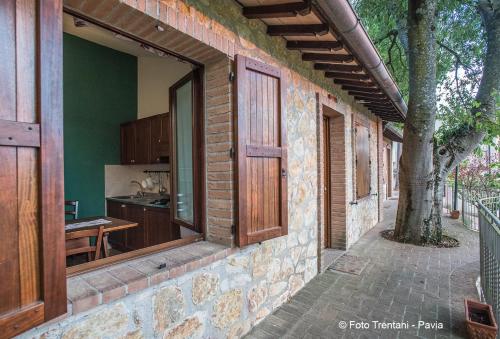 a brick building with an open door and a tree at SetterHouseAgriHotel in Trevi