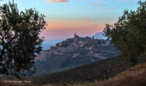 a castle on top of a hill at sunset at SetterHouseAgriHotel in Trevi