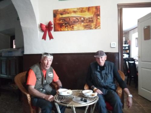 two men sitting at a table with cups at ALBERGUE CASA BAZTAN in Uterga