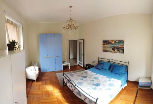Un dormitorio con una cama con sábanas azules y una lámpara de araña. en Assarotti Centre Apartment en Génova