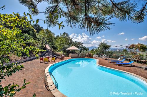 a swimming pool in a resort with chairs and tables at SetterHouseAgriHotel in Trevi