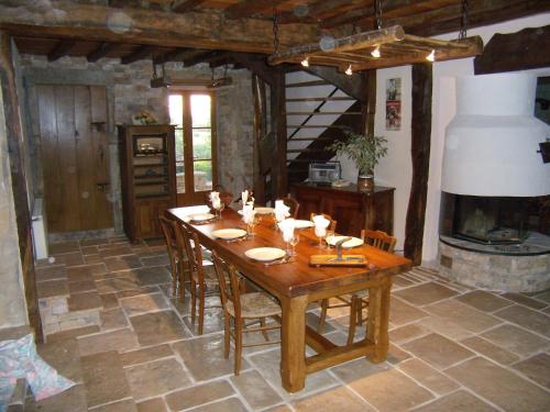 une salle à manger avec une table et une cheminée dans l'établissement La chaumière de Laives, à Laives