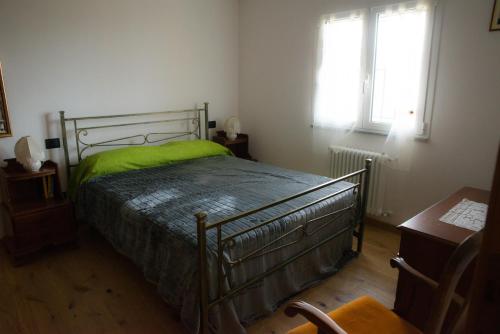 een slaapkamer met een bed met een groene deken erop bij Brenin in Varazze