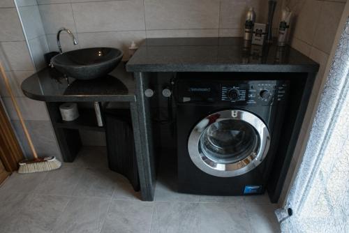 een badkamer met een wasmachine en een wastafel bij Brenin in Varazze