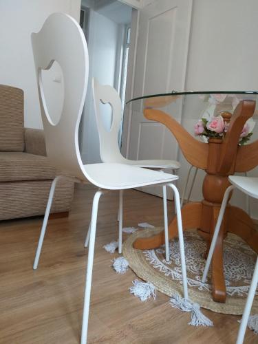 a glass table and white chairs in a living room at Farol de vida 2 in Coimbra