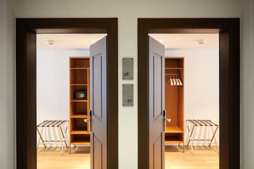 two open doors in a room with chairs at Italian Lifestyle Hotel & Osteria Chartreuse in Thun