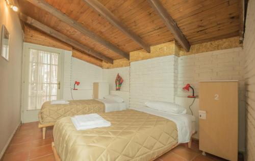 una camera con due letti in una stanza con soffitti in legno di Mosaic Home a Tirana