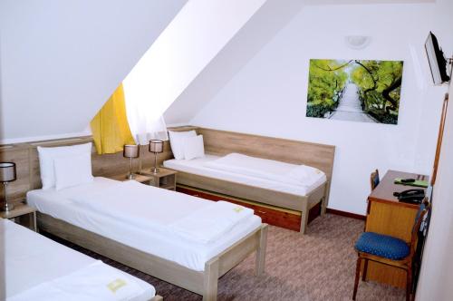 Pokój hotelowy z 2 łóżkami i biurkiem w obiekcie Kőkapu Vadászkastély és Hotel & Apartments w mieście Nagyhuta
