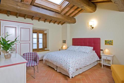 a bedroom with a bed and a red headboard at Locanda La Casina Di Lilliano in Castellina in Chianti