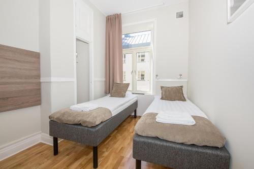two beds in a room with a window at City Hotell Avenyn in Gothenburg