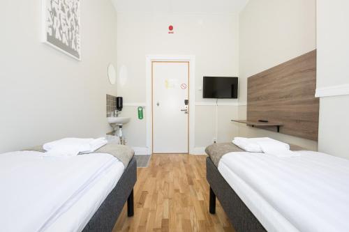 a hotel room with two beds and a tv at City Hotell Avenyn in Gothenburg