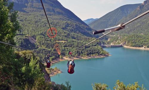 two people on a zip line over a lake at Anayet Sweet Home in Formigal