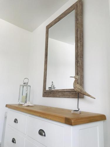 a bird sitting on top of a dresser with a mirror at Nancie's Place - - A BEAUTIFUL GEORGIAN DUPLEX APARTMENT - - Centre of Old Dartmouth Town - - ONSITE PRIVATE PARKING in Dartmouth