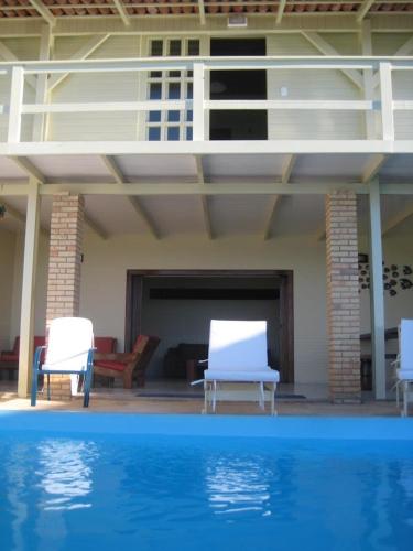 two chairs and a swimming pool in a house at Pousada Azul Marinho in Canoa Quebrada