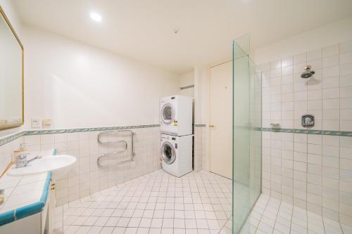 uma casa de banho com uma máquina de lavar roupa e um lavatório em Studio 5E em Wellington