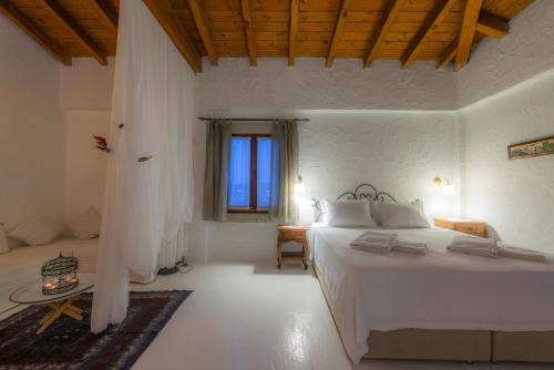 a bedroom with a large white bed and a window at Jakamar Alacati in Alacati