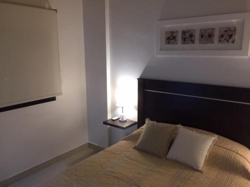 1 dormitorio con 1 cama y 1 lámpara en una mesa en Studio 44 en Belén de Escobar