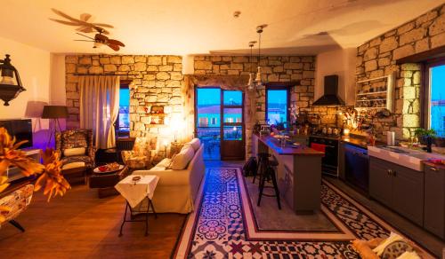 a living room with a couch and a kitchen at Jakamar Alacati in Alacati