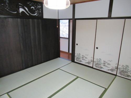 a room with white floors and cabinets and a chandelier at Aki Kokubunji Shukubou in Higashihiroshima