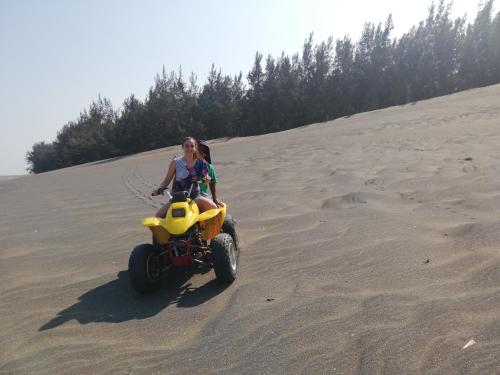 a woman riding a quad bike in the sand at Hotel Villa Marán Chachalacas Ambiente Familiar in Chachalacas