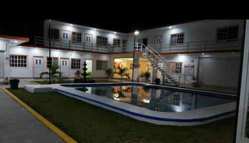 a house with a swimming pool at night at Hotel Villa Marán Chachalacas Ambiente Familiar in Chachalacas