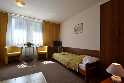 Habitación de hotel con cama, mesa y sillas en Arka Kraków, en Cracovia