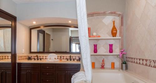 a bathroom with a tub and a sink and a mirror at Sonoran Sky 3BR 1202 UpperSkyby Casago in Puerto Peñasco