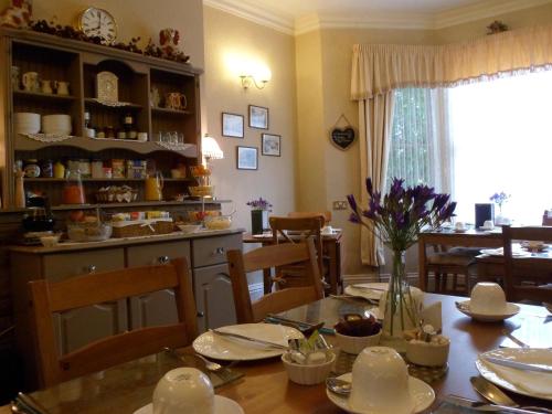 a dining room with a table and a kitchen at The Farthings in York