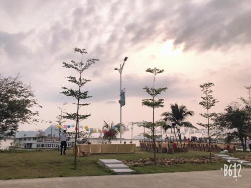 a person standing in a park with palm trees at Sun Bay Tuan Chau Hotel in Ha Long