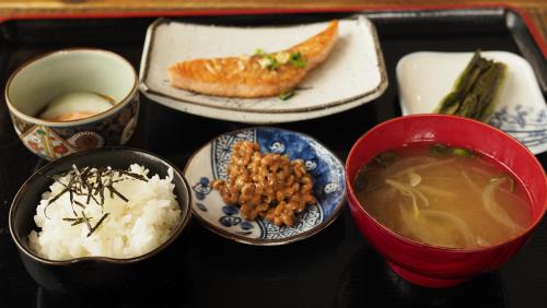 a tray of food with bowls of soup and rice at Winterland Lodge & Taproom in Nozawa Onsen