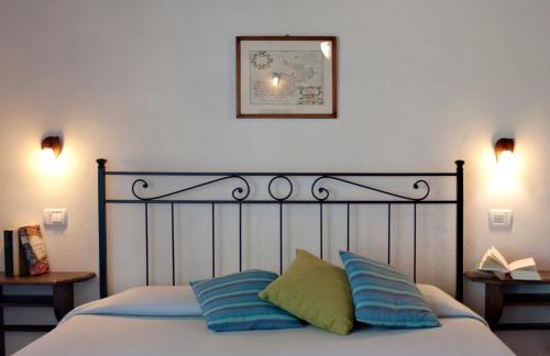 a bed with two pillows and a picture on the wall at Hotel Santo Stefano in Portoferraio