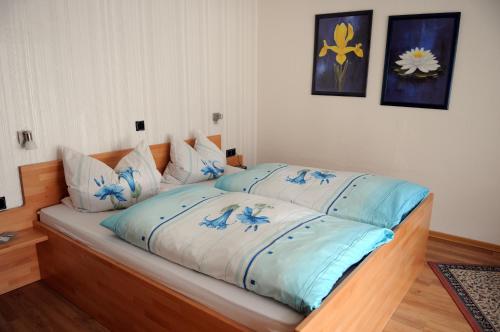 a bed with blue and white sheets in a room at Gästehaus Petra in Ürzig